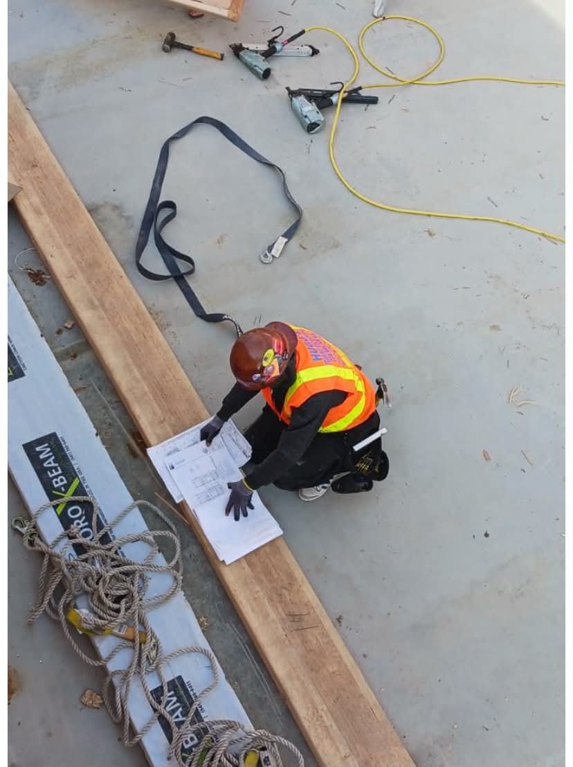 Hugo's Framing crew member reviewing blueprints on the job site before starting work
