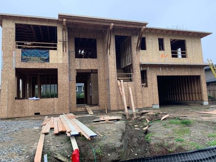 Modern custom home under construction with large framed window openings