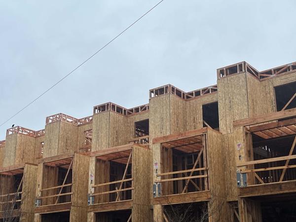 Close-up of framed rooftop balconies and chimney chases on a multi-unit building