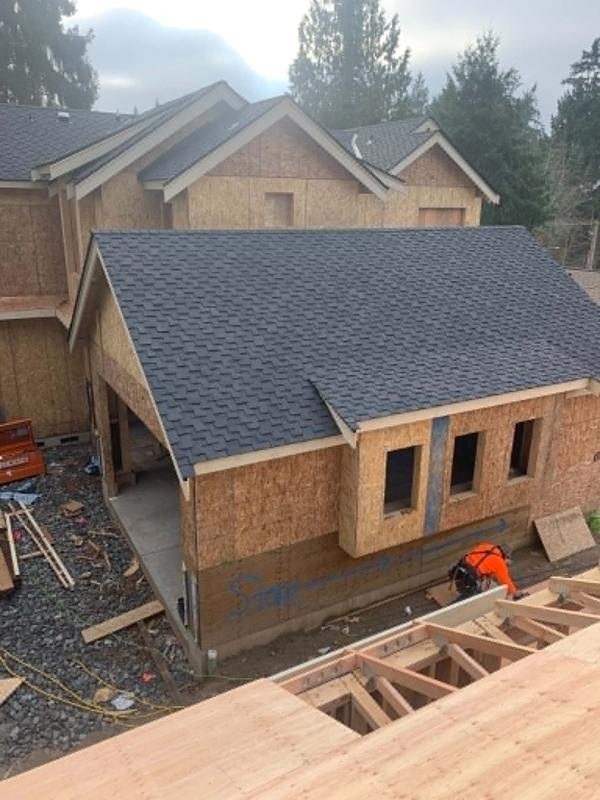 Crew member sheathing a roof on a multi-unit townhome building
