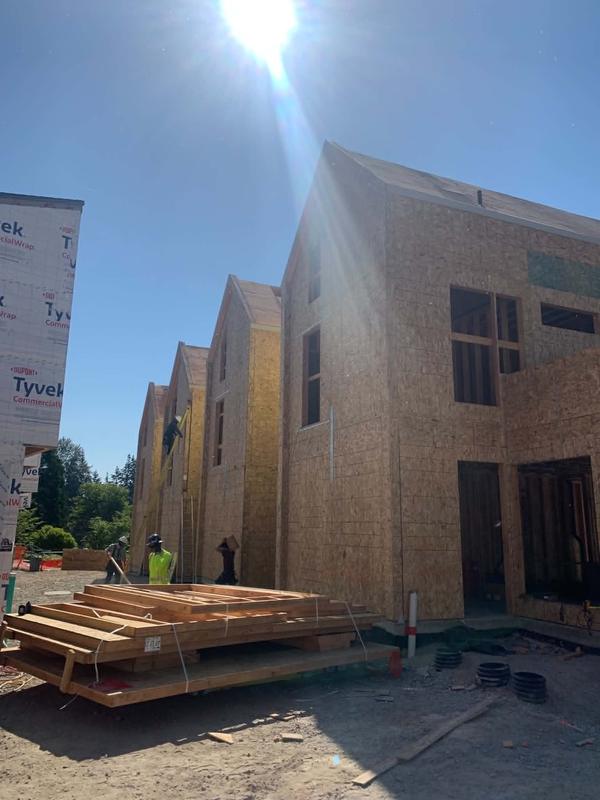 Row of townhomes with house wrap and sheathing under construction