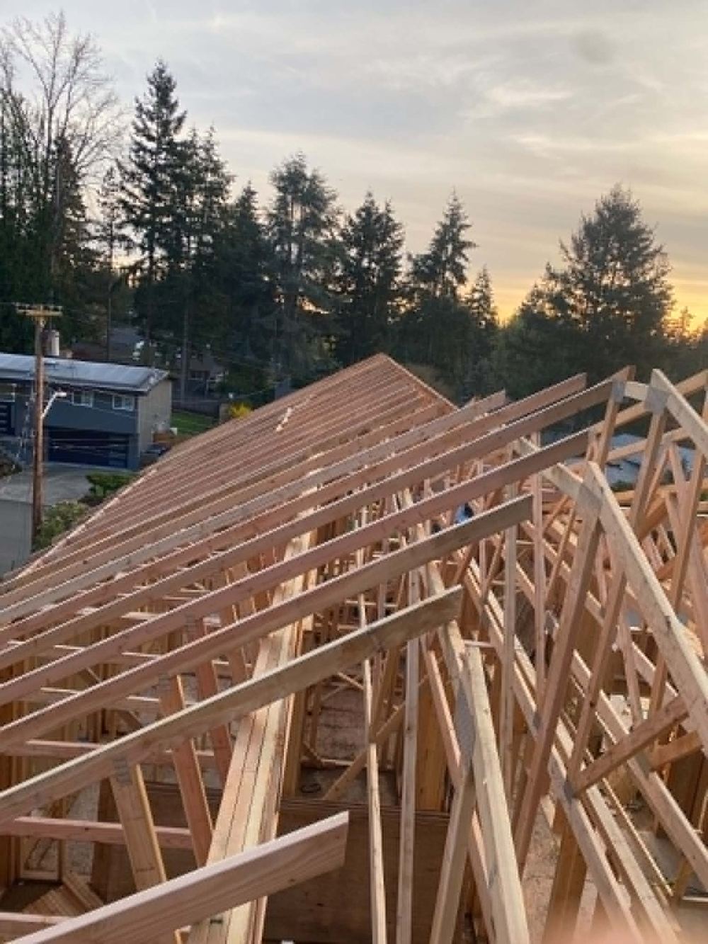Roof truss framing at sunset on a custom home build in Washington State